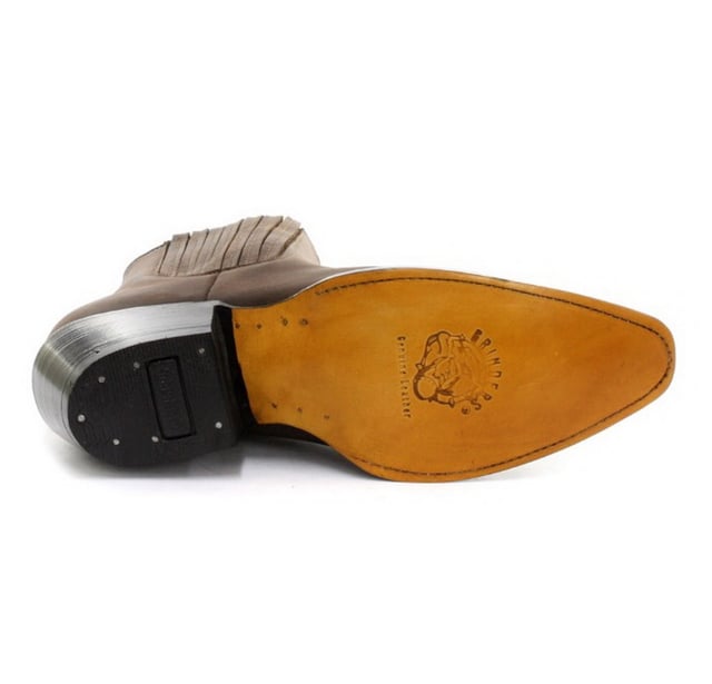 Este par de botines estilo western está fabricado íntegramente en cuero para lograr un aspecto y una sensación sofisticados. La parte superior es resistente a la abrasión para una mayor durabilidad y, para agregarle carácter, presentamos detalles de costuras intrincadas en la parte delantera. La parte delantera del zapato se completa con una puntera puntiaguda y los costados cuentan con una línea superior elástica, así como dos presillas con la marca para ponérselas fácilmente. La suela de este zapato tiene la marca del bulldog de Grinders y se ha unido con calor a una vira para brindarle a este zapato mayor resistencia y durabilidad. • Costura Goodyear • Parte superior de cuero • Forro de cuero suave • Tacones de cuero apilados • Suelas de cuero • Fabricado en México