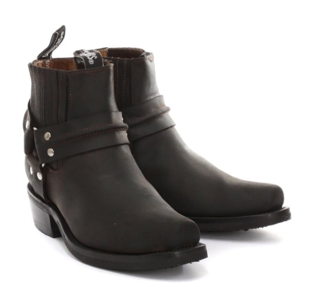 This classy leather boot appears in a low leg silhouette and features a stud detailed tri harness design that wraps around the boot and is connected by a metal ring. The slip-on design of these shoes is enhanced by the use of branded pull-on loops and stitched twin side elasticated gussets that make these boots easy to get on and off. For an added durable quality, the sole of this boot is welted using the Goodyear method, which is known for providing strength and long last to shoes. • Low Leg Harness Boots • Goodyear Welted sole • Shoe upper is crafted from premium leather • Features a soft leather lining • Rubber soles • Made in Mexico