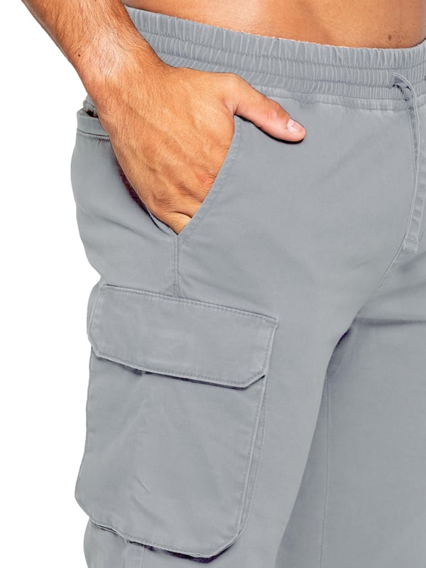 Pantalones cargo Enzo para hombre. Ajuste regular, pierna recta, lavado con enzimas. Diseño de 5 bolsillos. 2 bolsillos laterales, 2 bolsillos cargo con cierre de velcro. Bolsillo trasero único. Cintura elástica con cordón ajustable.