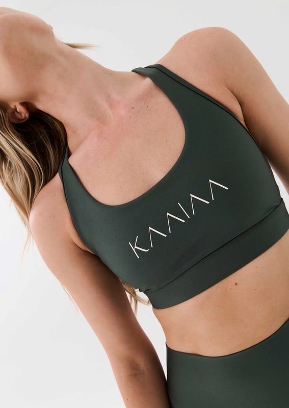 Scoop neck sports bra with a racer style back. Built in elasticated underbust support. KAAIAA logo print at front and back. P.E Nation logo print at back