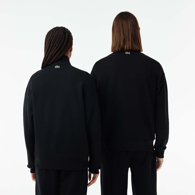 Unisex Lacoste Loose Fit High Neck Sweatshirt in Black. Finest materials, brand’s singular expertise. The perfect expression of Lacoste’s timeless wardrobe.- Loose fit is loose ease on body and sleeves, lower shoulders and armholes.- Half zipped sweatshirt in organic heavy French terry with big croc 80' on chest.- Unisexe.- Zipped high collar in shell fabric.- 7cm iconic original badge crocodile.- 3cm green crocodile at under middle back collar. Material: 100% Organic Cotton. Ref: SH0069031.