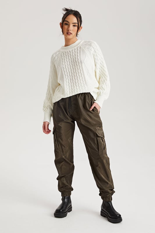 Model is 5'6 and wears a size S.Pockets. Drawstring waist band. Cuff hem. Introducing our Khaki Parachute Cargo Trouser, a versatile and stylish addition to your wardrobe that effortlessly combines functionality with fashion-forward design. Crafted with attention to detail and quality, this cargo is perfect for those who seek comfort without compromising on style.