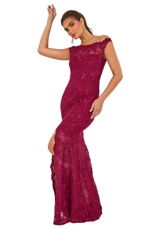 Lace Scallop Edge Front Split Maxi Dress from Roman. Get ready to make a statement in our stunning lace maxi dress. The feminine bardot neckline is adorned with delicate scalloped lace details, adding a touch of elegance to the look. Crafted from a stretch woven fabric, this bodycon dress hugs your shape beautifully and finishes at a flattering maxi length with a mermaid edge and front split for added drama. Pair with heels and a bolero for an unforgettable look!