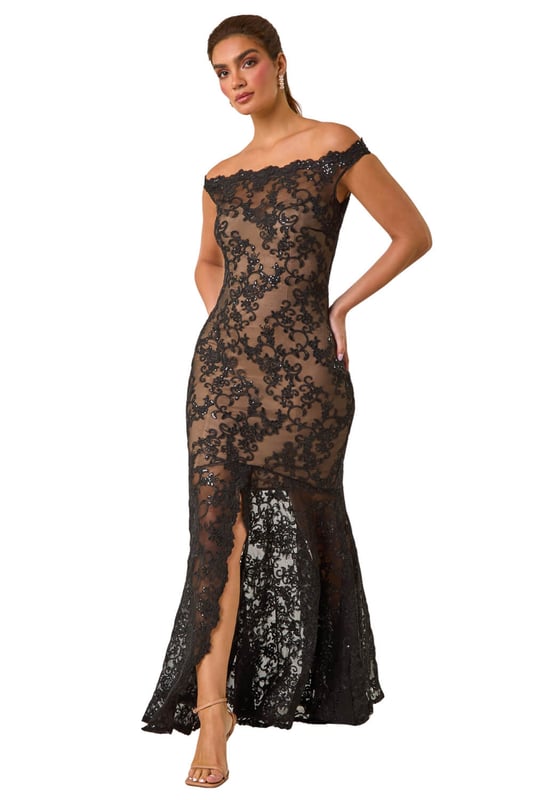 Lace Scallop Edge Front Split Maxi Dress from Roman. Get ready to make a statement in our stunning lace maxi dress. The feminine bardot neckline is adorned with delicate scalloped lace details, adding a touch of elegance to the look. Crafted from a stretch woven fabric, this bodycon dress hugs your shape beautifully and finishes at a flattering maxi length with a mermaid edge and front split for added drama. Pair with heels and a bolero for an unforgettable look!