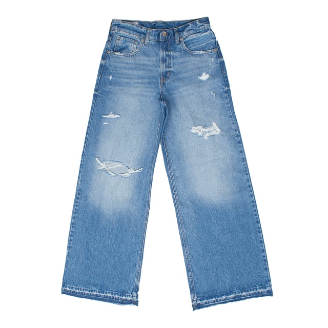 Estos jeans de tipo wide leg y tiro medio presentan un estilo desenfadado y moderno con detalles desgastados y rasgados en la parte frontal, que añaden un toque rebelde y casual al diseño. 

Su corte amplio desde la cadera hasta el tobillo garantiza comodidad y libertad de movimiento, mientras que el clásico diseño de cinco bolsillos mantiene la funcionalidad tradicional de los vaqueros. 

Perfectos para quienes buscan un look juvenil, relajado y lleno de personalidad, estos jeans combinan comodidad y estilo de manera equilibrada.
 Composición: 100% Algodón
 Cuidados:
- Lavar a máquina con agua fría.
- Utilizar colores similares en el lavado.
- Evitar el uso de blanqueadores.
- Secar a baja temperatura en secadora.
- Planchar a baja temperatura.
- No lavar en seco.