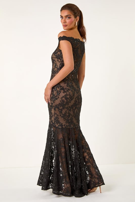 Lace Scallop Edge Front Split Maxi Dress from Roman. Get ready to make a statement in our stunning lace maxi dress. The feminine bardot neckline is adorned with delicate scalloped lace details, adding a touch of elegance to the look. Crafted from a stretch woven fabric, this bodycon dress hugs your shape beautifully and finishes at a flattering maxi length with a mermaid edge and front split for added drama. Pair with heels and a bolero for an unforgettable look!