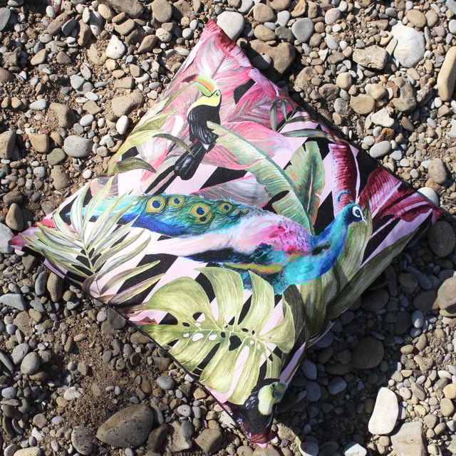 Add drama to your garden with a striking jungle themed cushion. This cushion captures a Toucan and Peacock on a backdrop of tropical leaves and flowers in their bright and natural colours, which makes it a beautiful addition to any home.