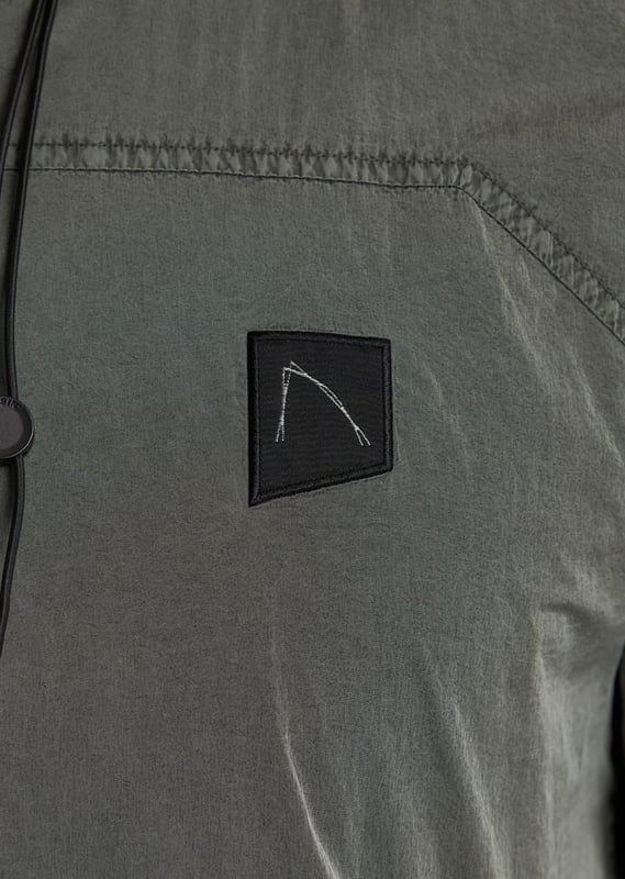 The Ortega is a regular fit summer jacket made from garment dyed polyamide for a unique color. It features a 2-way zip with tonal webbing tape, 2 side pockets, and an interior pocket with a zipper. Signature details include the CHASIN' comma badge and branded cord stoppers. The lining is made from polyester mesh.