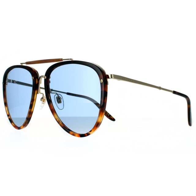 Gafas de sol aviador para hombre Gucci Havana azul. Las gafas Gucci tienen un estilo aviador femenino, elaboradas en acetato ligero con detalles metálicos contrastantes. Las lentes de poliamida en forma de lágrima están enmarcadas en plástico, con una barra superior distintiva, puente metálico y almohadillas nasales ajustables. Las patillas metálicas súper delgadas están terminadas con un grabado del logo de Gucci.
