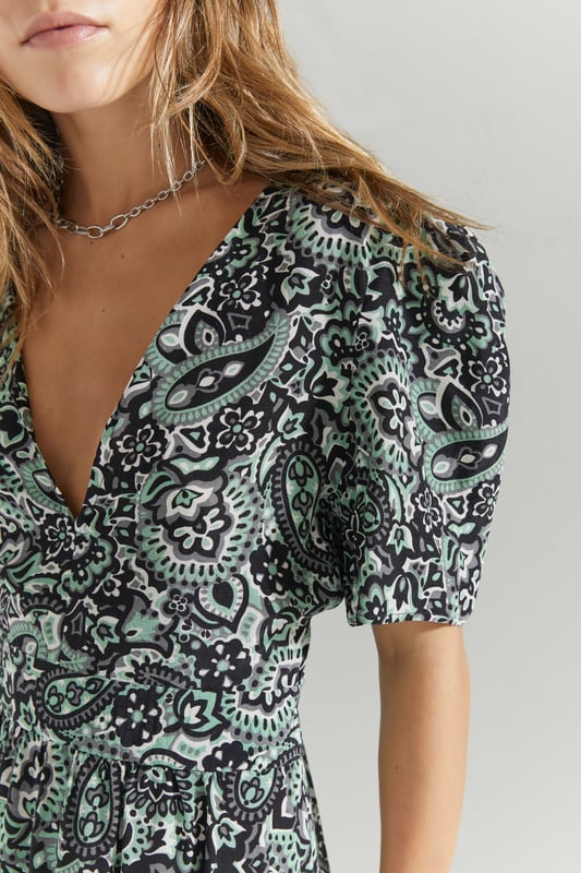 Green and beige floral print maxi dress. V neck, ¬æ sleeves. Sewing at the waist. Large opening in the back and button fastening.