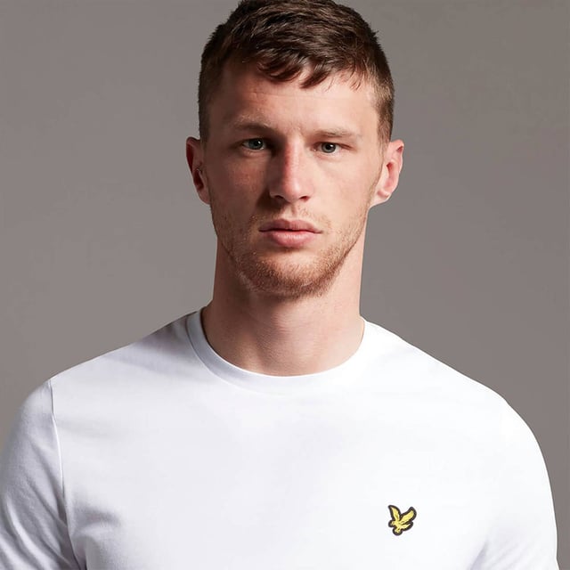 Crafted from 100% cotton from unrivalled softness, the Lyle & Scott Plain T-Shirt is an iconic style and the definition of a wardrobe staple. Featuring a classic silhouette, detail stitching at collar and cuff, plus our signature Golden Eagle, this t-shirt can be seamlessly layered or stand alone as the centrepiece of any smart-casual outfit.  
  
Fit: Regular
It is crafted to fit the body neither too tightly or too loosely, leaving you with a classic, timelessly stylish look. We recommend you order your usual size, but if you're caught between two, go a size up.