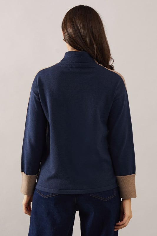 Asymmetric hem design for a modern twist
        Cosy roll neck for extra warmth and style
        Contrasting cuffs add a unique touch
        Relaxed tunic silhouette for comfort
        Versatile knitted fabric suitable for various occasions
    
    This Roll Neck Asymmetric Hem Tunic from Wallis is the epitome of sophisticated comfort. The asymmetric hem creates a flattering silhouette, while the roll neck offers both warmth and elegance. Perfect for those who appreciate a touch of glamour in their everyday wear, this tunic can be styled for various occasions. Pair it with wide-leg trousers and ballet flats for a chic daytime look, or dress it up with tailored trousers and heeled boots for evening gatherings. The contrasting cuffs add a subtle yet striking detail, making this piece stand out in your wardrobe. Whether you're attending a family lunch or meeting friends for coffee, this versatile tunic will keep you looking polished and feeling comfortable throughout the day.