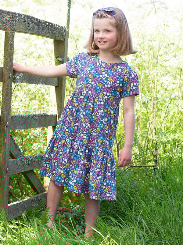 95% organic cotton 5% elastane | Proud to be certified to the Global Organic Textile Standard (GOTS) | Flower patch all-over print | Single jersey with a little bit of stretch (180-190 gsm) | Tiered style | Coconut button shoulder opening (up to and including size 3 years) | Short sleeved | Round neck | Made in Turkey | Machine washable at 40 degrees, or at 30 degrees to be kinder to the planet