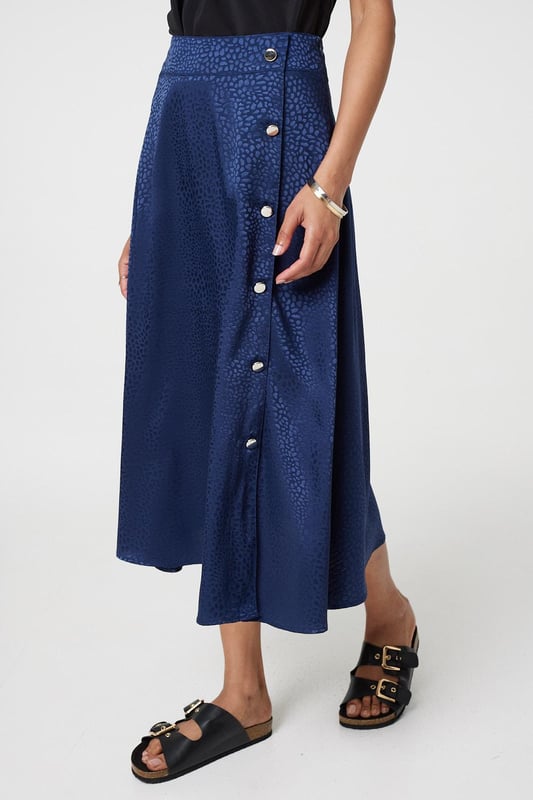 This elegant skirt has a silky satin texture with a flattering a-line cut. It fastens with button details and has a high waist fit, with a midi length hem. Tuck your favourite t-shirt, top or jumper into the waistband for an elevated casual look.