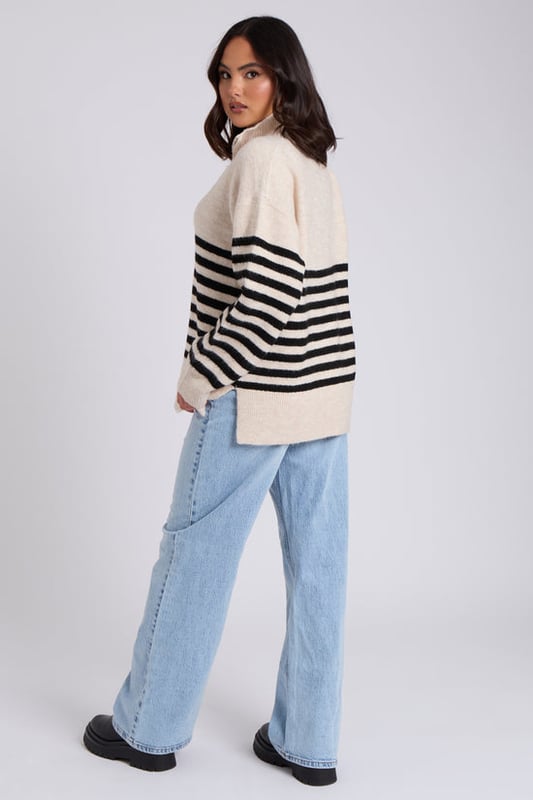 Model is 5'6 and wears a size S. Half Zip, Oversized, Stripe detail. We are excited to introduce our new Half Zip Stripe Jumper, a perfect blend of style and comfort. Featuring a contemporary half-zip design and bold stripe pattern, this jumper is versatile enough for both casual and smart-casual looks. Crafted from high-quality materials, it offers warmth and a relaxed fit, making it a staple for any wardrobe. Whether you're layering it for cooler days or making a statement on its own, the Half Zip Stripe Jumper is sure to elevate your outfit with ease and sophistication.