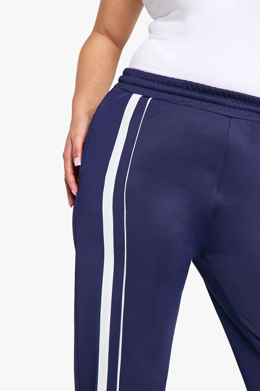 Straight fit joggers for a relaxed silhouette
        Side stripes add a sporty, contemporary touch
        Comfortable jersey fabric for all-day wear
        Wide leg design for effortless movement
        Versatile style suitable for various casual occasions
    
    Embrace comfort without compromising on style with these plus-size joggers from Boohoo. The straight fit and wide leg design offer a flattering silhouette while ensuring unrestricted movement. The side stripes lend a trendy, athletic-inspired look that's perfect for the fashion-forward woman. Pair these versatile joggers with a fitted white tee and trainers for a laid-back daytime ensemble, or dress them up with a cropped jacket and statement jewellery for a chic evening out with friends. The soft jersey fabric makes these joggers ideal for lounging at home, running errands, or attending casual family gatherings. For a coordinated look, match with the hoodie as shown in the image, completing an outfit that's both cosy and stylish. These joggers are a must-have addition to your wardrobe, offering endless styling possibilities for the modern, confident woman who values both comfort and fashion.