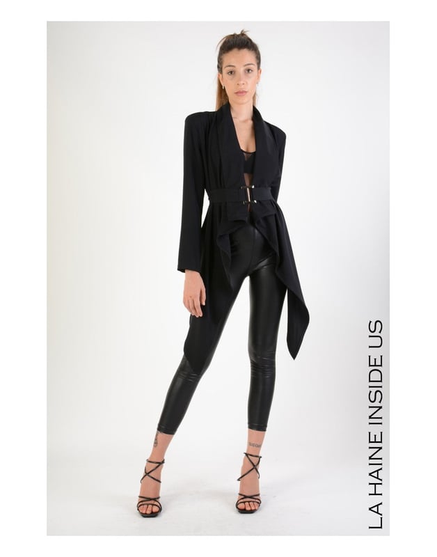 Ein Blazer mit asymmetrischem Schnitt ist die perfekte Wahl für Personen, die einen modernen und stilvollen Look schätzen, der sich von klassischen Designs abhebt und jeder Garderobe eine Prise Avantgarde hinzufügt.

Mit zwei eingesetzten Taschen, die nicht nur Eleganz verleihen, sondern auch äußerst praktisch sind, ermöglichen sie das Verstauen kleiner Gegenstände, ohne die Linien der Silhouette zu stören.

Mit Schulterpolstern, die die Schultern subtil betonen und der Figur ein definiertes und professionelles Aussehen verleihen, ideal für wichtige Meetings und formelle Anlässe.

Mit einem zusätzlichen Gürtel mit Metallschnalle, der nicht nur Stil hinzufügt, sondern auch eine perfekte Anpassung des Blazers an die Körperkontur ermöglicht, wobei die Taille betont wird und dem Ganzen ein elegantes Finish verliehen wird.

Aus hochwertigem Stoff gefertigt, der Haltbarkeit und Tragekomfort gewährleistet, während er gleichzeitig luxuriös und elegant aussieht, was den Blazer zu einer langfristigen Investition macht.