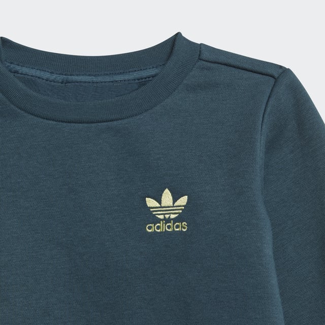 Your little one was born to explore. This infants' crew set was made to keep them comfy on every adventure. Fleece fabric cradles them in softness from head to toe. Trefoils on the front and side keep the look authentically adidas.adidas' cotton products support more sustainable cotton farming.  - Regular fit - Sweatshirt: Ribbed crewneck with button placket (up to size 86) - 70% cotton, 30% polyester (recycled) - Sweatshirt: Ribbed cuffs and hem - Pants: Medium rise - Pants: Drawcord on elastic waist - Supports the Better Cotton Initiative - Pants: Side pockets  Shipped by adidas