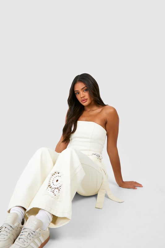 Intricate crochet design for a unique, textured look
        Wide-leg silhouette for a relaxed, on-trend fit
        Strapless bodice with a flattering straight neckline
        Matching belt to cinch the waist and add definition
        Delicate lace trim detailing for added femininity
    
    Make a statement in these eye-catching crochet jeans that blend comfort with style. The wide-leg cut offers a relaxed fit that's perfect for casual outings, while the strapless bodice adds a touch of allure. Style these jeans with a cropped cardigan and trainers for a laid-back daytime look, or dress them up with strappy sandals and statement earrings for evening drinks with friends. The versatile design makes them ideal for summer festivals, beach holidays, or casual weekend brunches. The matching belt allows you to customise the fit, accentuating your waistline. These jeans are a must-have addition to your wardrobe, offering a fresh take on denim that's sure to turn heads wherever you go.