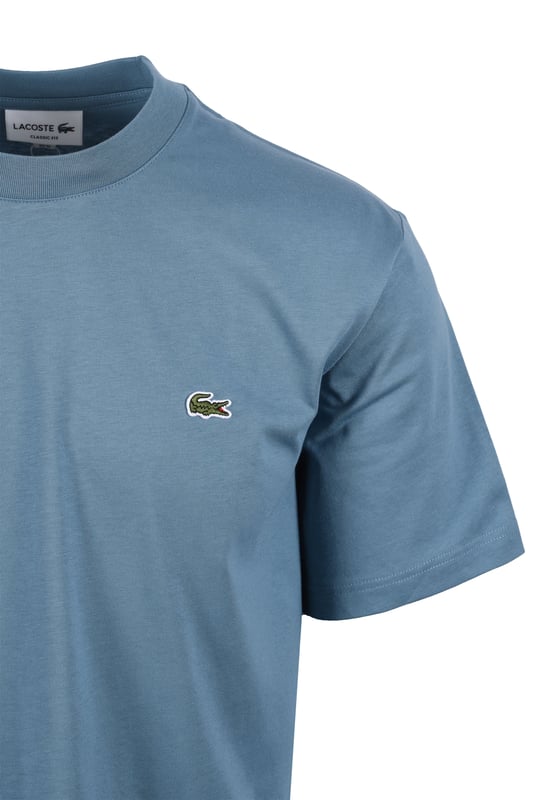 Lacoste Tee in Limestone
Experience the difference with the Lacoste Limestone Tee, a testament to Lacoste's legacy of sportswear excellence since 1933. Crafted from premium Peruvian Pima cotton, this essential tee offers superior comfort and durability. The exceptionally fine, lightweight fabric boasts a subtle sheen and a robust construction, making it a wardrobe staple you can rely on.
 
Features

Premium Pima Cotton: Experience the luxurious feel of 100% Peruvian Pima cotton, known for its superior softness and durability.
Lightweight Fabric: The 130 GSM fabric provides breathability and comfort for all-day wear.
Classic Fit: A regular, straight cut offers a timeless silhouette that looks great on everyone.  Please note: If you are between sizes, we recommend ordering one size up for a more comfortable fit.   
Iconic Branding: The embroidered crocodile on the chest adds a touch of signature Lacoste style.   
Versatile Style
Style code: TH7318
