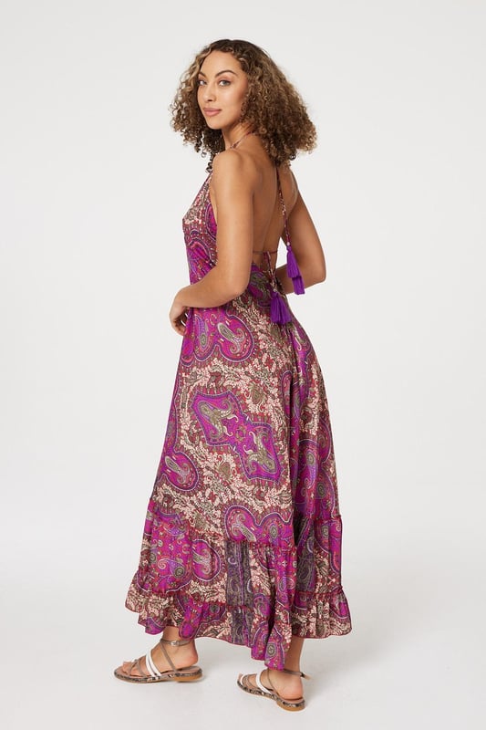 Add a statement print to your holiday closet with this maxi sun dress. It has a self-tie halter neck, sleeveless fit and a tiered maxi length skirt. Pair with flat sandals for an elegant poolside style, or elevate with heeled espadrilles for an evening out.