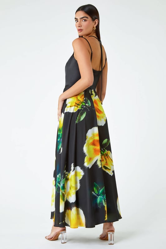 Luxe Floral Fit & Flare Maxi Dress from Roman. Feel glamorous in this luxurious floral maxi dress. Designed in a glamorous silhouette that cinches you in at the waist, this fit and flare gown features a strappy bodice with gold toggles. A flattering v-neckline and tie at the back adds more femininity to the dress, finishing at a floor sweeping full length. It has a romantic floral print, adjustable cami straps and concealed back zip to fasten. From Summer Weddings to formal dinners, this special occasion dress is sure to turn heads at any event this year.
