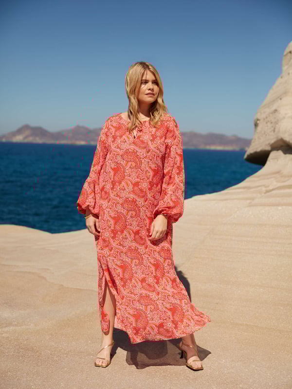 Printed all over with a pretty red paisley print, this dress is cut from a soft woven fabric that moves beautifully. It has a V-neckline with fixed tie detailing, as well as full-length raglan sleeves with elasticated cuffs. Its maxi length makes it the perfect throw-on piece, ideal for any holiday or summer look.
