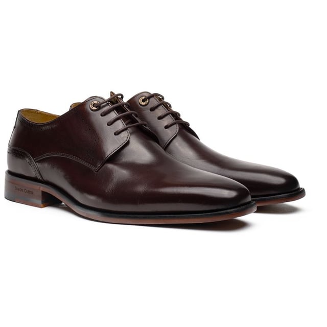 Presentamos el Zapato Derby Warren de Simon Carter, una perfecta combinación de sofisticación atemporal y peculiaridad pulida. Estos zapatos excepcionales redefinen el estilo clásico Derby con sus detalles únicos y encantadores. Meticulosamente elaborados con cuero de primera calidad, los Zapatos Derby Warren cuentan con un diseño elegante y esbelto, que irradia una sensación de refinamiento. Ya sea que te vistes para un evento formal o que desees añadir un toque de distinción a tu vestimenta diaria, este básico del armario de calzado de Simon Carter asegura que hagas una declaración distintiva de estilo y personalidad.
