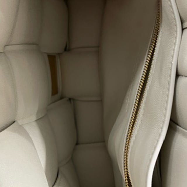 VINTAGE, RRP WIE NEU  
Setzen Sie ein Statement mit der Bottega Veneta Padded Cassette Bag aus weißem Lammleder. Diese Umhängetasche strahlt Luxus aus mit ihrem gepolsterten Intreccio-Lederdesign und der eleganten weißen Farbe. Das Innere bietet eine einzelne Reißverschlusstasche, die praktischen Stauraum für Ihre Essentials bietet, während der Metallverschluss für eine sichere Befestigung sorgt. Das gefütterte Lammleder fügt einen Hauch von Raffinesse hinzu, ergänzt durch die Hardware in Goldfarbe. Hergestellt in Italien verkörpert diese exquisite Tasche das makellose Handwerk und die zeitlose Eleganz, die mit Bottega Veneta assoziiert wird. Ob zu lässigen oder formellen Ensembles kombiniert, diese Tasche ist ein elegantes und vielseitiges Accessoire für den modebewussten Einzelnen.  

Bottega Veneta Padded Cassette Bag aus weißem Nappa-Leder  
Zustand: Ausgezeichnet  
Abnutzungsspuren: Kein Verkaufsetikett, Keine sichtbaren Abnutzungsspuren.  
Verpackung: Keine  
Farbe: Weiß | Ecru  
Material: Leder | Lammleder  
Größe: Einheitsgröße  
Maße: Breite: 50; Höhe: 165; Länge: 270  
SKU: NAPPUGBBA372493W
