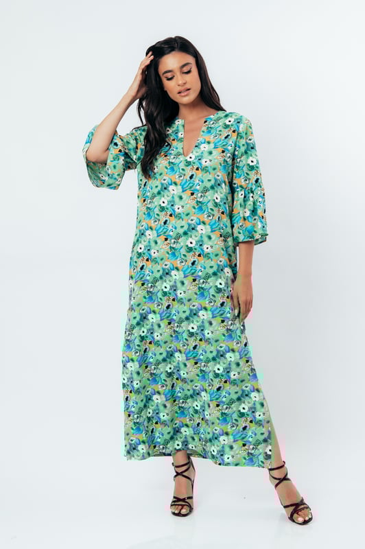 Deze zomerjurk in kaftanstijl met bloemenprint is gemaakt van geweven viscose. Het heeft een mandarijnkraag en een V-halslijn. De mouwen zijn lang met ruches aan de manchetten. De zoom heeft grote zijsplitten. Deze jurk heeft een lang, los, recht silhouet.