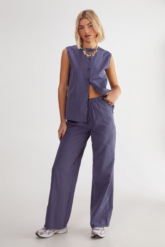 Straight leg design for a classic silhouette
        Vertical stripe pattern adds visual interest
        High-waisted fit for a flattering look
        Side pockets for practicality
        Coordinating sleeveless top with unique front opening
    
    Make a statement with these eye-catching stripe straight leg trousers from NastyGal. The vertical stripe pattern elongates your figure, while the high-waisted design accentuates your curves. Pair with the matching sleeveless top for a coordinated ensemble that's perfect for casual outings or family gatherings. The straight leg cut offers versatility, allowing you to style with trainers for a laid-back look or dress up with heels for a more polished appearance. The side pockets add functionality to this fashionable piece. For a trendy twist, layer with a cropped jacket or oversized blazer. These trousers are a wardrobe essential that can be dressed up or down, making them ideal for various casual occasions throughout the year.