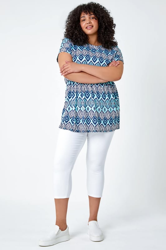 Curve Aztec Print Stretch Top from Roman. Top of the tops, this trendy tunic top is sure to become a favourite. Ideal for Spring, this Curve blouse has a flattering fit and flare shape with a comfortable elasticated waist. The bold aztec print is getting us holiday ready whilst the classic short sleeve shape keeps you cool all Summer long. Style with cropped stretch trousers and sandals for jet-set-ready styling this season.