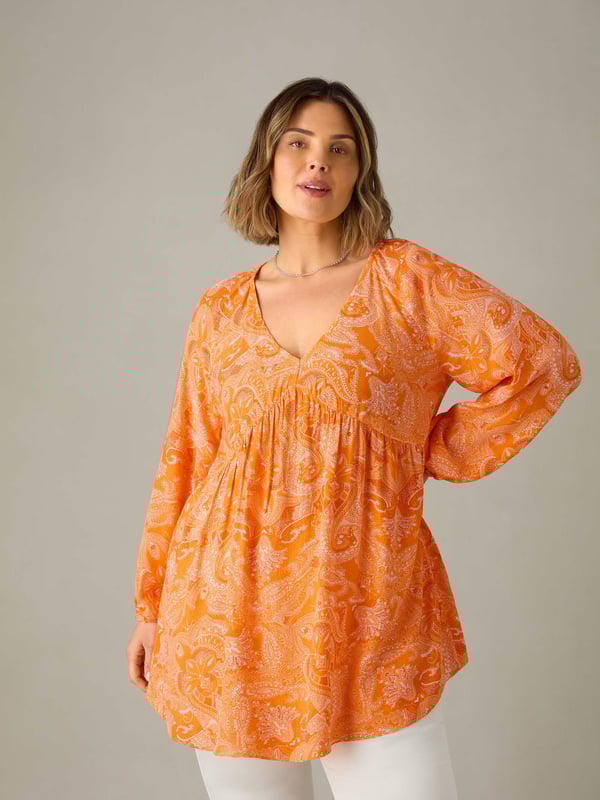 In a pretty orange paisley, this tunic is cut from a soft woven fabric thats so comfortable to wear. With a lengthening V-neckline, it has a bust seam and full-length elasticated sleeves which create a stylish silhouette. Its long, tunic length adds to its flattering feel, making it the perfect everyday piece.