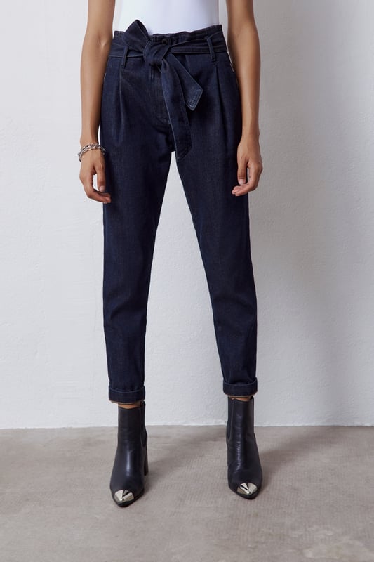 High waist paperbag jeans with removable belt. Two side patch pockets with rhinestone details. Button and zip fastening.