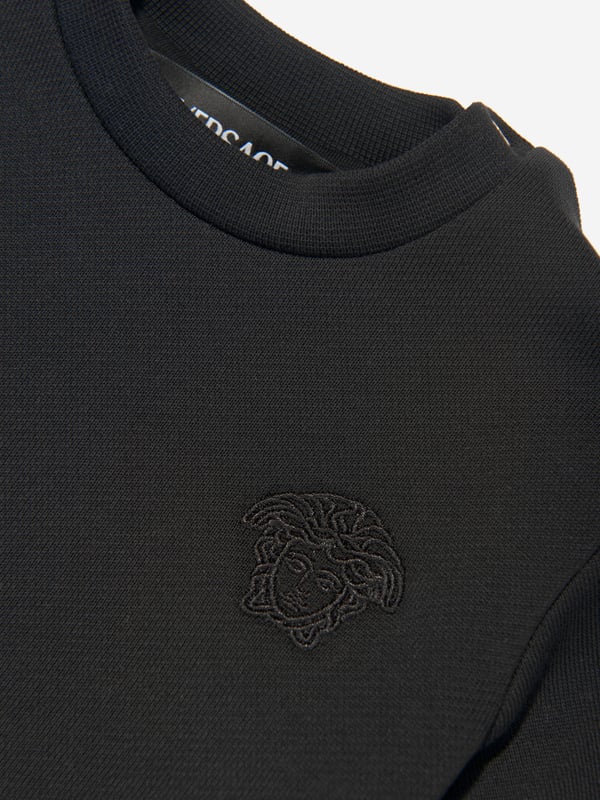 Versace envision bold, innovative abstracts in their beautifully haute couture abstracts. This baby girls black sweater dress encapsulates the Italian label's passion for daring and unparalleled technology. Envisioned in soft, stretchable knit fabric via a yellow and black striking baroque motif. It showcases an embroidered logo on the left wrist with a satin skirt that has a slight ruching/pleating effect. ‚ Long Sleeves‚ Round Neckline‚ Black Embroidery ‚ 100% Cotton