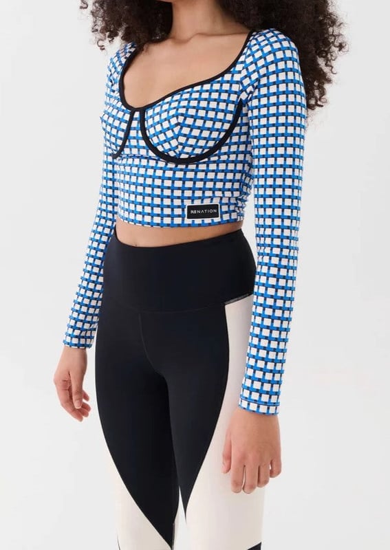 The Emergence LS Top is cut in a hyper soft scuba style fabrication. With a blue, white and beige geo print throughout which is contrasted by a sculpted black binding. Shaped underwire support. Finished with a P.E Nation silicon badge at the hem.