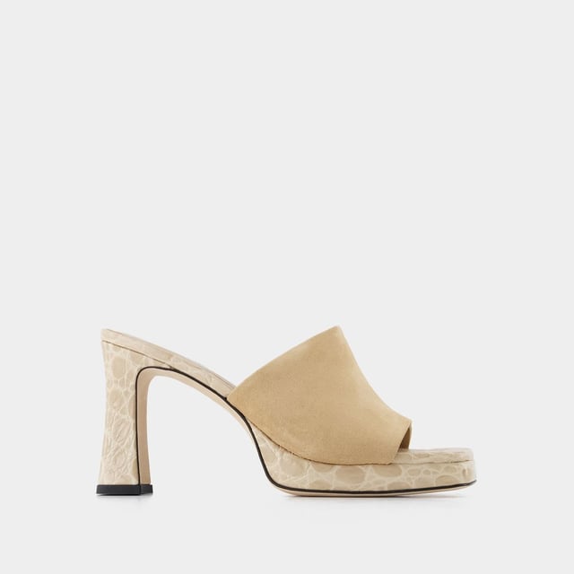By Far Estas mules son auténticas joyas. Con su combinación de ante y piel con relieve de cocodrilo, ¡son el accesorio perfecto para cualquier conjunto! Cómodos gracias a su plataforma, te acompañarán a todas partes. Altura del tacón: 9 cm. Altura de la plataforma: 1 cm. Material principal: piel de becerro repujada en cocodrilo. Material de la suela: cuero. Material del forro: cuero. Cierre: fácil de poner. Forma de la puntera: cuadrada abierta. Ajuste: fiel a la talla - Tallaje: europeo.