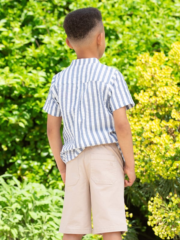 100% organic cotton | Proud to be certified to the Global Organic Textile Standard (GOTS) | Navy blue and cream stripe | Woven stripe fabric | Functional coconut button opening | Single front chest pocket | Short sleeved | Low cut standing collar | Made in India | Machine washable at 40 degrees, or at 30 degrees to be kinder to the planet