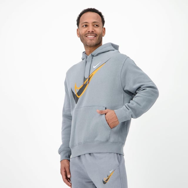 Nike Standard Issue Moto Overhead Hoodie in Grey. - -. A throw-on-and-go easy overhead-style hoodie featuring an adjustable drawstring cotton-lined hood and ribbed cuffs and hem for a great streetwise layering piece. - -. Made from a midweight brushed fleece that feels super-soft on the inside and smooth on the outside, keeping you cosy while the structured build maintains its shape. - -. Large contrast Swoosh graphic print to chest and smaller Swoosh to back of hood.