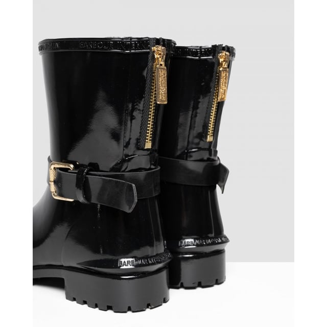 Botas mugello negras Barbour International para mujer, fabricadas en caucho y suela de caucho. Presentan: acabado de alto brillo, suela de perfil bajo, marca Barbour, hebilla decorativa y estilo motero.