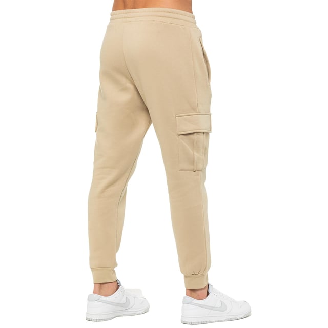 Enzo Mens Regular Fit Cargo Joggers. Features 2 Side Slash Pockets, 2 Cargo Pockets, Single Welt Back Pocket. Brushed Back Inner Fleece. Elasticated Waistband With Adjustable Drawstring. Cuffed Ankle. Features EZ Logo.