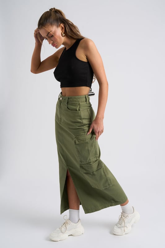 Model is 5'6 and wears a size S. Slim fit. High Waisted. Midi length. Introducing our Khaki Soda Cargo Skirt, a versatile and stylish addition to your wardrobe that effortlessly combines functionality with fashion-forward design. Crafted with attention to detail and quality, this skirt is perfect for those who seek comfort without compromising on style.