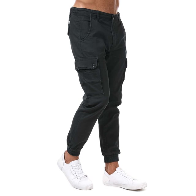 Pantalones cargo ajustados para hombre Jack Jones Paul Warner en negro. - Cierre de botón. - Bolsillos laterales. - Bolsillos con botón en la parte trasera y en las piernas. - Lavado enzimático ecológico que proporciona un aspecto desgastado. - Prenda de tejido de sarga con elasticidad. - Marca en la parte trasera. - Puños acanalados. - Ajuste entallado. - Material principal: 98% algodón 2% elastano. Lavable a máquina. - Ref: 12167596