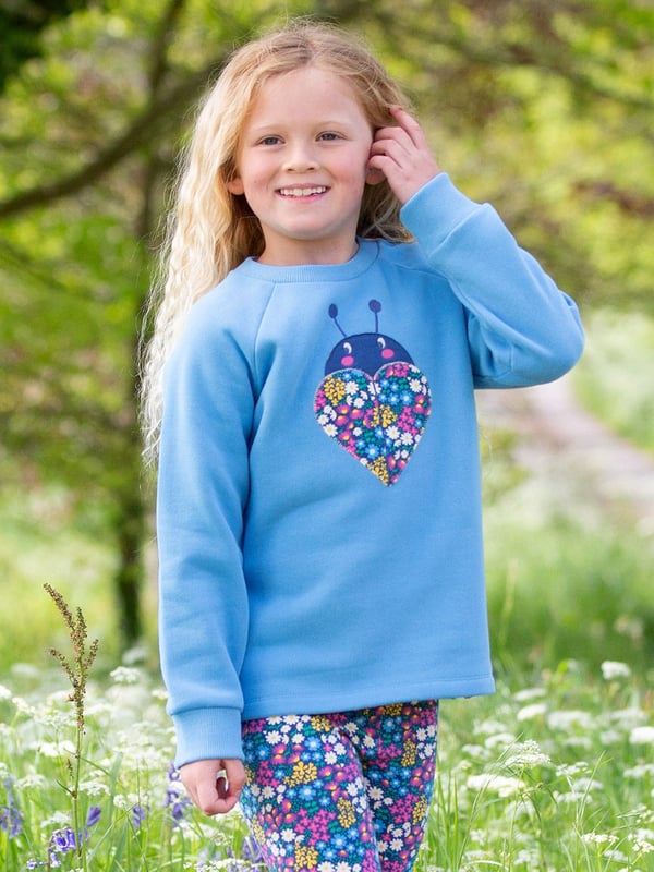 100% organic cotton | Proud to be certified to the Global Organic Textile Standard (GOTS) | Ladybird appliqué design featuring our flower patch print | OEKO-TEX Standard 100 (Product class I) appliqué backing | Cornflower blue | Brush back sweat fabric 3 ply (290-300 gsm) | Coconut button raglan sleeve opening (up to and including size 3 years) | Long sleeved | Round neck | Ribbed neckline and cuffs | Made in Turkey | Machine washable at 40 degrees, or at 30 degrees to be kinder to the planet