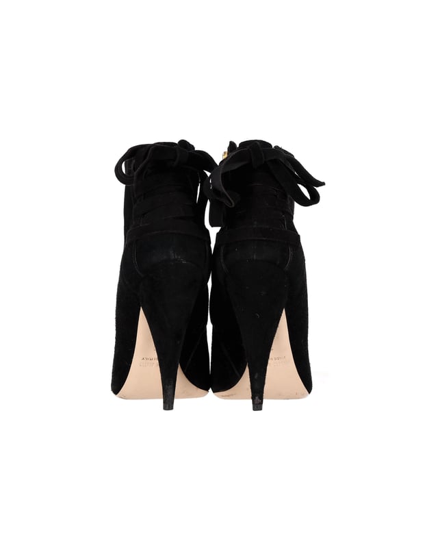 VINTAGE, UVP WIE NEU  
Tauchen Sie ein in eine Welt unvergleichlicher Eleganz mit den Miu Miu Stiefeletten aus schwarzem Wildleder. Diese opulenten Stiefeletten, mit einem klassischen schwarzen Wildlederschaft und luxuriösen Lederakzenten, verfügen über eine semi-spitze Zehenform und auffällige Kegelabsätze, die Raffinesse und Stil ausstrahlen. Mit verdeckten Reißverschlüssen an den Seiten für einen nahtlosen Abschluss sind diese Stiefel der Inbegriff von High-End-Mode und bieten eine perfekte Mischung aus Eleganz und Anziehungskraft für die moderne Fashionista.

Mit Staubbeutel

Miu Miu Stiefeletten aus schwarzem Wildleder  
Farbe: schwarz  
Material: Wildleder  
Zustand: Sehr gut  
Größe: EU36  
Maße: Absatzhöhe: 110; Einlegesohlenlänge: 270  
Gebrauchsspuren: Geringe Abnutzungsspuren, leicht benutzt, aber sehr gut gepflegt. Kleine Markierung an den Sohlen & Faltenbildung, leichte Kratzer an den Sohlen und Absätzen.  
SKU: 368687