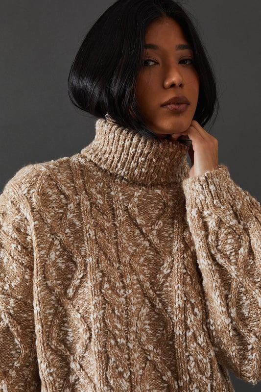 Intricate cable knit pattern for a textured look
        Cosy roll neck design for extra warmth
        Relaxed, oversized fit for comfort and style
        Dropped shoulders for a contemporary silhouette
        Ribbed cuffs and hem for a snug finish
    
    This Cable Knit Roll Neck Jumper from Warehouse is the epitome of casual chic. The intricate cable knit pattern adds depth and interest to your outfit, while the oversized fit creates a relaxed, effortless vibe. Perfect for those chilly autumn days or cosy winter evenings, this jumper is versatile enough to dress up or down. For a laid-back look, pair it with wide-leg jeans and trainers, as shown in the image. To dress it up a bit, try tucking the front into a leather midi skirt and adding ankle boots. The neutral tone makes it easy to style with various colours and textures in your wardrobe. Whether you're heading to a casual family gathering or meeting friends for a coffee, this jumper will keep you warm and stylish. Its timeless design ensures it will remain a staple in your wardrobe for seasons to come.