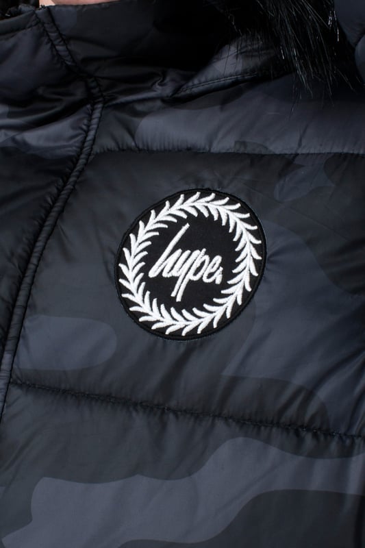 Imagine a completely versatile jacket that features both the parka and puffer style. Meet the HYPE. Kids Camo Explorer Jacket, part of the HYPE. 2022 Back to School collection. Designed in our standard unisex explorer parker shape, in our signature camo print in khaki and brown. Finished with an arm pocket and embossed justhype logo zip puller and a faux fur brown neutral hood trim. Machine wash at 30 degrees to keep in new condition.