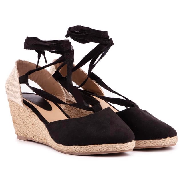 Dale un toque final a tu estilo veraniego con esta cómoda sandalia cuña que fusiona con un zapato de tacón de Solesister. El tacón de yute estilo alpargata se combina con una parte superior en negro y natural, mostrando finos tirantes alrededor del tobillo y un ajuste más amplio. La adición perfecta a tus looks para climas cálidos.