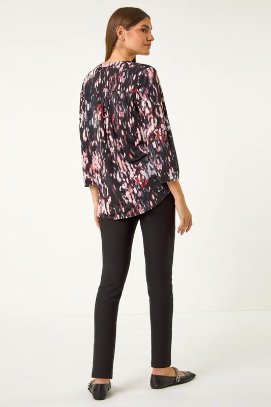 Textured Abstract Print V-Neck Stretch Top from Roman. Unleash your signature style this Autumn Winter with our abstract print shirt. Designed in a soft, stretchy jersey fabric, this shirt features a striking 3D abstract puff print for an eye-catching look. The flattering v-neckline adds a touch of sophistication, while the shoulder pleat details, front button fastenings, and 3/4 length tabbed sleeves create a trendy finish. Style with jeggings and ankle boots for both casual and smart occasions!
