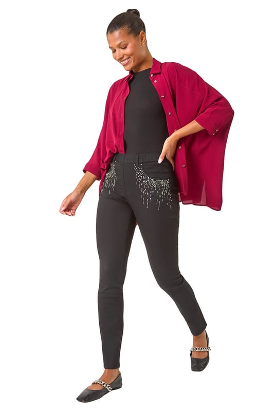 Hotfix Pocket Jegging from Roman. Add some sparkle to your denim collection with these embellished hotfix pocket jeggings. Crafted from a comfortable stretch denim fabric, these jeggings feature a pull-on style for ease and comfort. The standout hotfix pocket trim detail adds a touch of glamour to your casual look. Perfect for the Autumn/Winter season, style these jeggings with knitwear and trainers for a chic and cosy outfit!